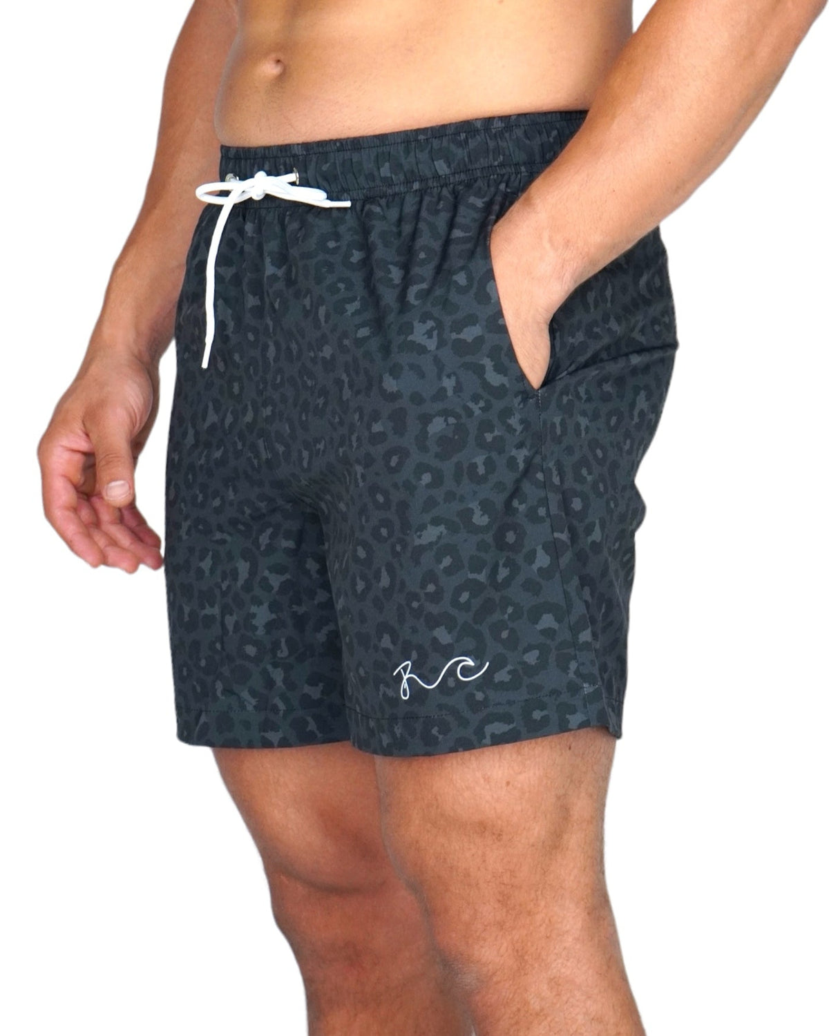 A man wearing dark gray and black leopard-print swim trunks with a white drawstring and a white script logo near the hem, shown against a plain white background.