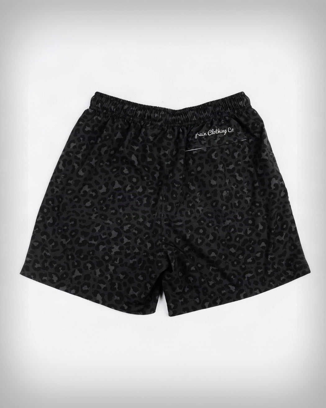 Black leopard print shorts with an elastic waistband and a small white embroidered logo on the left hip, shown flat against a white background.