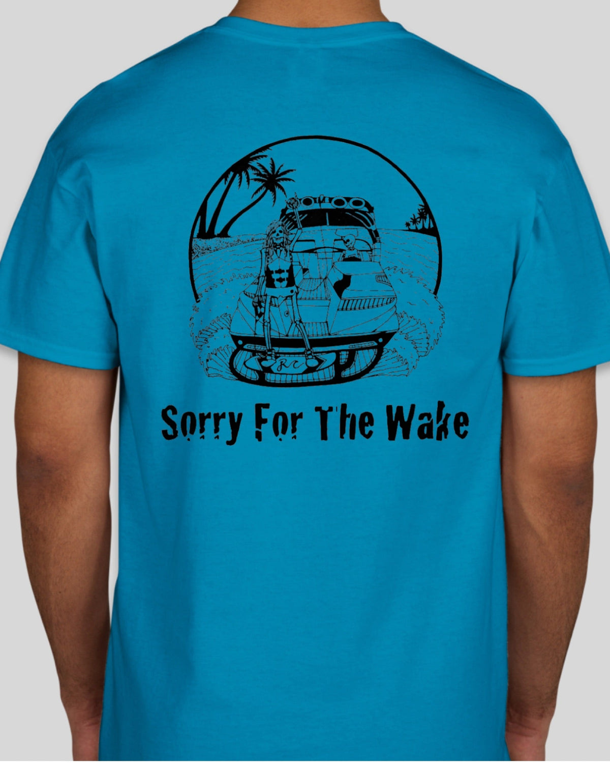A man wearing a bright blue t-shirt, viewed from the back. The shirt features a black graphic of a car driving through water with palm trees, inside a circle, with the text 'Sorry For The Wake' printed below.