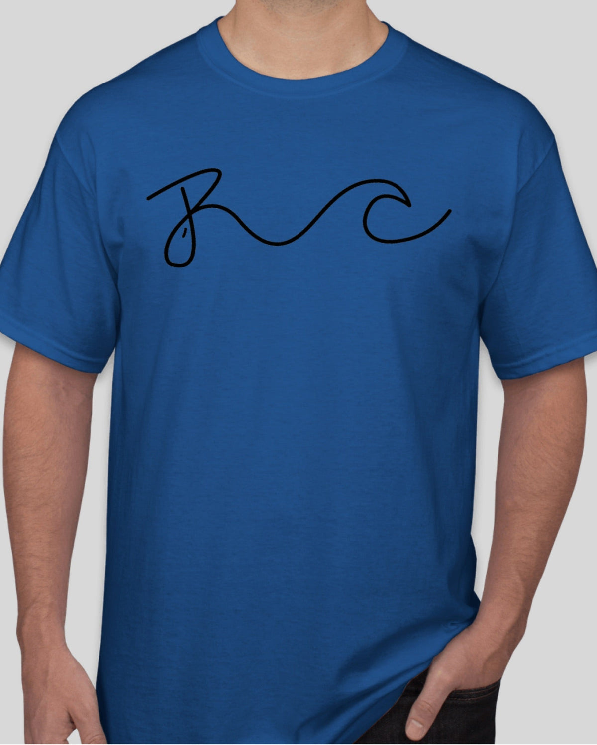 A person wearing a royal blue short-sleeve crewneck t-shirt with a black cursive 'BC' graphic across the chest, shown against a solid light gray background.